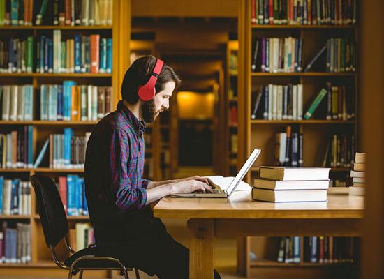 博彩平台推荐 student working on homework in the library.